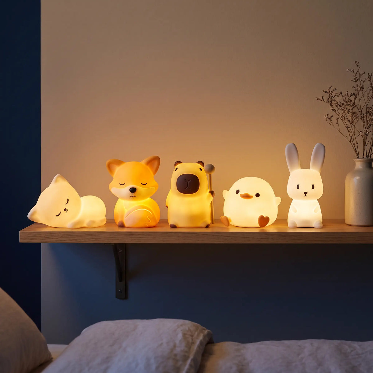 Cinq veilleuses animaux Halume allumées sur une étagère : chat, renard, capybara, canard et lapin