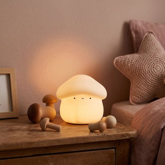 Veilleuse champignon en silicone Halume allumée sur une table de chevet dans une chambre d'enfant